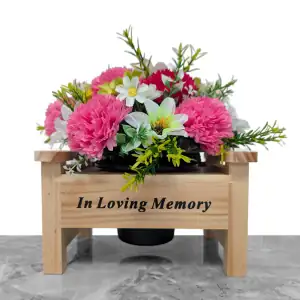Artificial white dahlias, cerise & pink carnations, and white & green cosmos, with gyp and greenery in a sturdy wooden 'In Loving Memory' memorial bench with plastic grave flower pot.