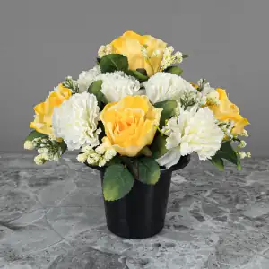 Artificial pale yellow roses & cream carnations, with gyp and greenery in a full black plastic grave flower pot.