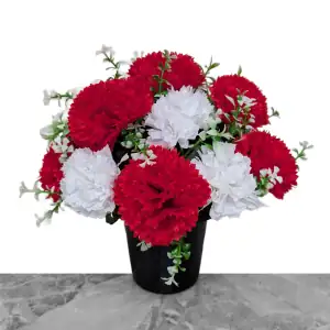 Artificial red & white carnations, with gyp and greenery in a full black plastic grave flower pot.