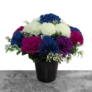 Artificial royal blue, honeydew, purple & mauve carnations, with gyp and greenery in a full black plastic grave flower pot.