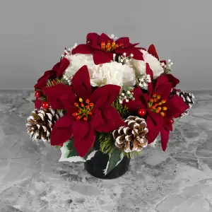Artificial dark red velvet poinsettias, ivory carnations, berries and snowy pinecones with gyp and greenery in a full black plastic grave flower pot.